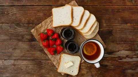 White cup of black tea with lemon. Sandwiches with strawberry and jam jar Stock Photos