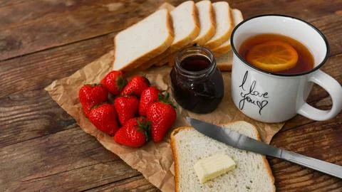 White cup of black tea with lemon. Sandwiches with strawberry and jam jar Stock Photos