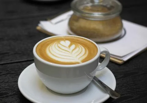 White cup of caffe latte with rosetta latte art and saucer Stock Photos