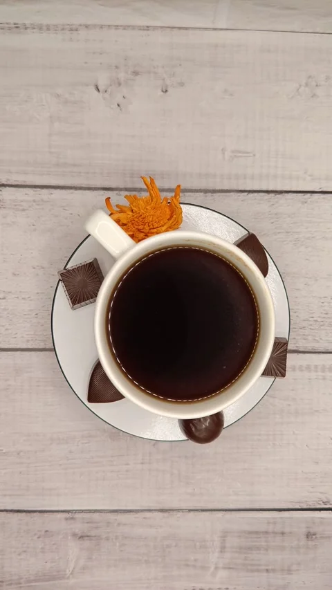 White cup with coffee and chocolate smoothly rotates around the light background Stock Footage 329936873