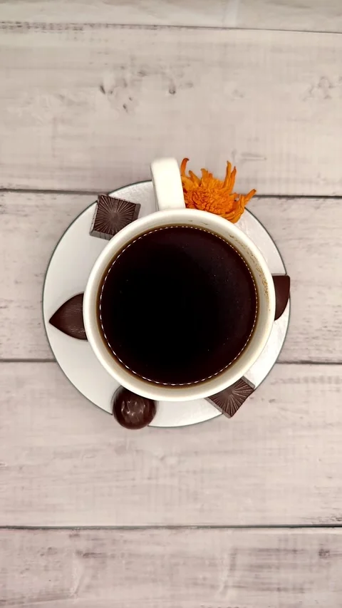 White cup with coffee and chocolate quickly spins around top view Stock Footage 329939194