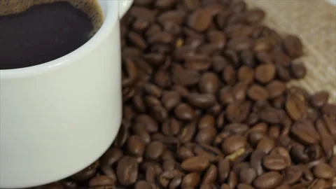 White cup with coffee on the background of fresh roasted coffee beans Stock Footage 195904374