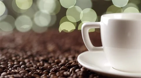 White cup on the coffee beans on the background of lights Stock Footage 56425284