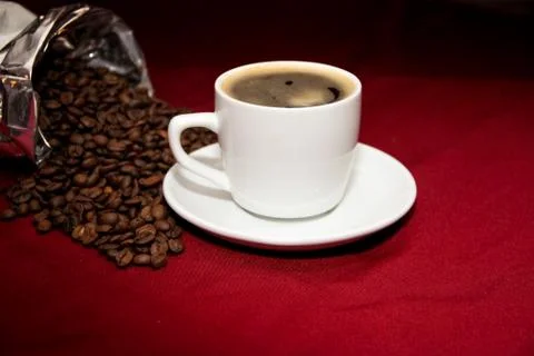 White cup of coffee with beans on background board Foto stock