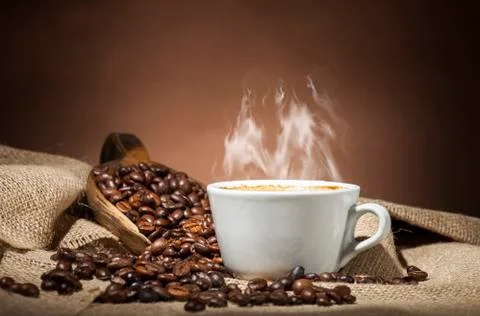 White cup with coffee beans Stock Photos