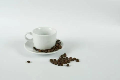White cup with coffee beans on a white background. Stock Photos