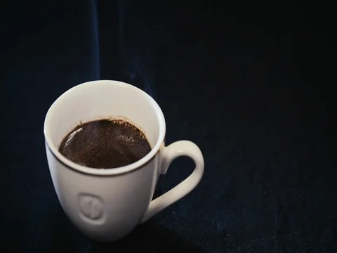 White Cup with coffee on black background, steam coming Video stock 73938404