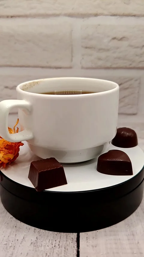 A white cup of coffee with chocolate quickly spins around a large Stock Footage 329939198