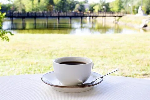 A white cup of coffee close-up is on the table Stock Photos