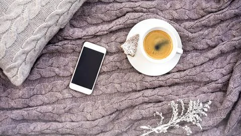 White cup coffee with cookie in form fir and white phone flower on gray pillo 스톡 사진