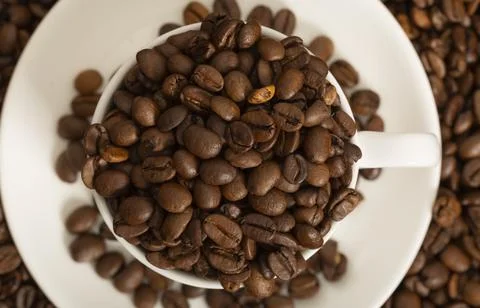 White cup with coffee grains close-up. View from above. Flat lay. Stock Photos