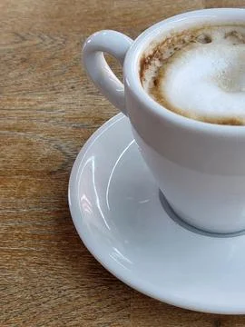 White cup of coffee on an oak table. Advertisement for coffee drinks Foto stock