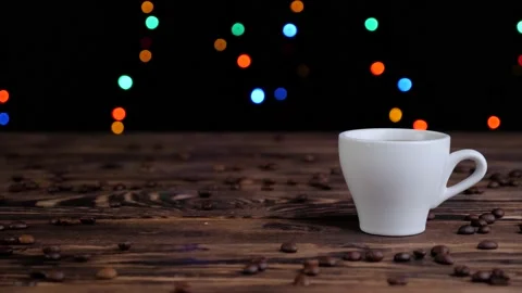 White cup of coffee with roasted coffee beans on a wooden table. Video stock 131004063