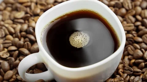 White cup of coffee on rotating table with coffee beans around. Fresh aromatic Video stock 305373766