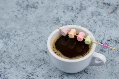 White cup with coffee on the table. marshmallows view from above. place for t Stock Photos