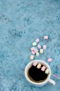 White cup with coffee on the table. marshmallows view from above. place for t Stock Photos