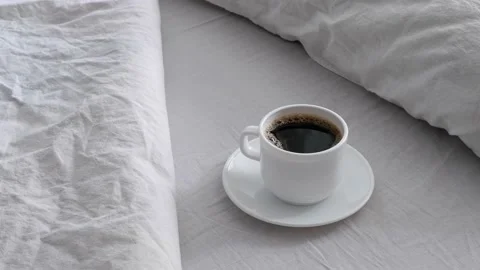 White cup with coffee on white bed linen. Stock Footage 155116778