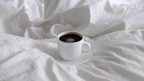 White cup with coffee on white bed linen. Stock Footage 155240673