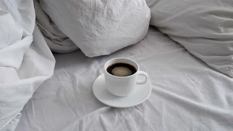 White cup with coffee on white bed linen. Stock Footage 156756341