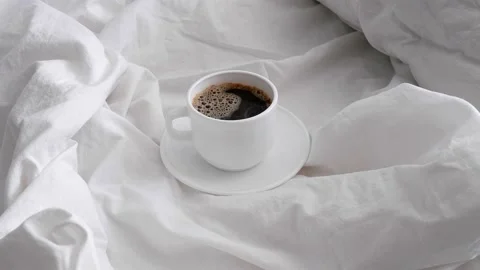 White cup with coffee on white bed linen. Stock Footage 157322721