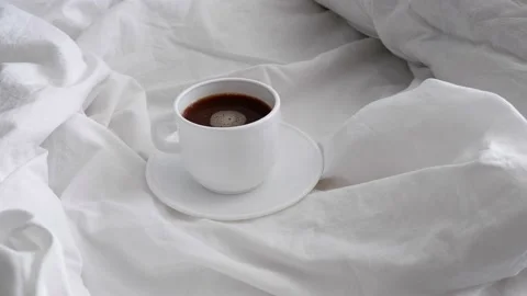White cup with coffee on white bed linen. Stock Footage 157444272