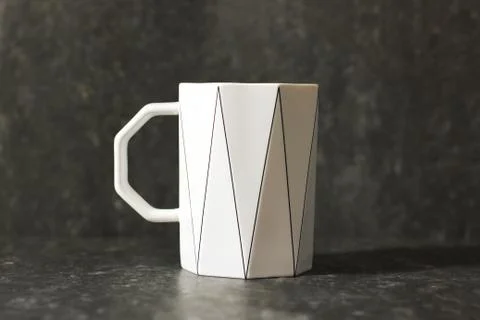 White cup on a dark background. Original cup Stock Photos