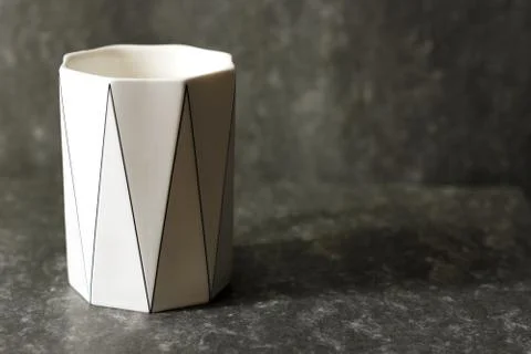 White cup on a dark background. Original cup Stock Photos