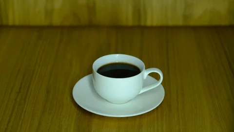 A white cup full of black coffee stands on a saucer Stock-Footage 129768018