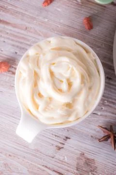 White cup full of sweet curd cheese on wooden board Stock Photos