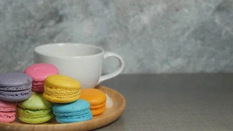 White cup of hot coffee and colorful macaroons dessert food on dish Stock Footage 75336451