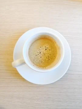White cup of hot coffee on table Stock Photos
