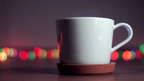 White cup of hot tea in a cork stand Stock Footage 99598365