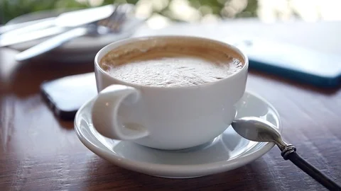 White cup of invigorating hot latte on the table. HD, 1920x1080, slow motion Stock Footage 96610599