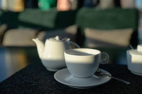 White cup with kettle on cafe table Stock Photos