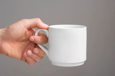 White cup in a man's hand. Stock Photos