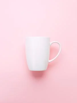 White cup on pink background. Stock Photos