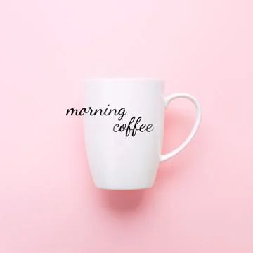White cup on pink background with text Morning Coffee. Stock Photos