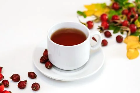 A white Cup of rosehip tea on a white surface Foto stock