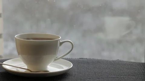 White  cup with steaming tea is in front of the window. Stock Footage 60661649