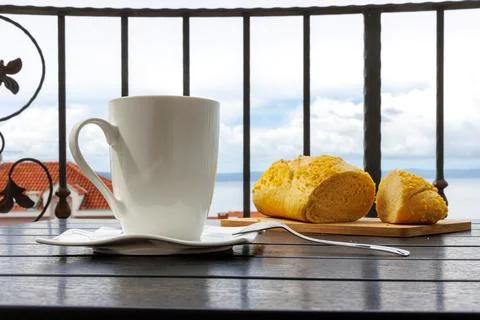 White cup of tea and croatian corn bread on a balcony table with the view o.. Stock Photos