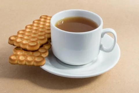 White cup of tea with biscuits Stock Photos