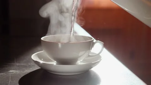 White cup of tea with hot aromatic tea, which gives off wonderful steam. Stock Footage 150569354