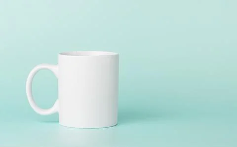 White cup for tea or coffee on a green background Stock Photos