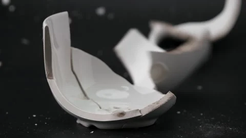 White cup for tea or soup broken by hammer blow isolated on black background. Stock Footage 248503745