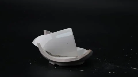 White cup for tea or soup broken by hammer blow isolated on black background. Stock Footage 248503761