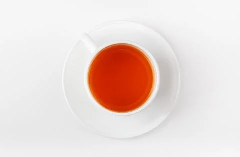 A white cup of tea on a white background. Morning black tea. Top view. Stock Photos