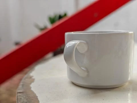 White cup on white table with blurred background Stock Photos