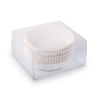 White cupcake paper forms in a plastic box isolated over white background Foto stock