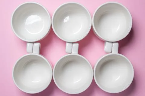 White cups on a pink background.  Stock Photos