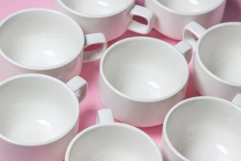 White cups on a pink background.  Stock Photos
